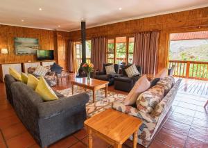 sala de estar con sofás y mesa en Highland Run Fly Fishing Estate by Dream Resorts, en Lydenburg