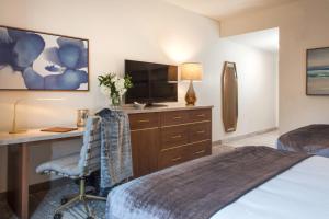 a hotel room with a bed and a desk and a television at Legacy Resort Hotel & Spa in San Diego