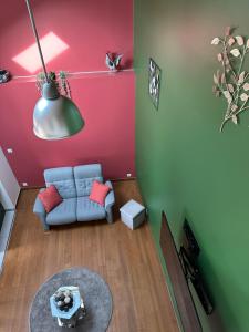 a living room with a blue couch and a red wall at Le cocoon in Forges-les-Eaux