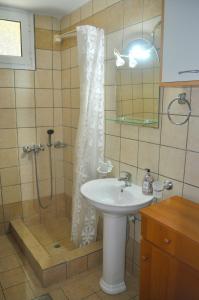 a bathroom with a shower and a sink at Villa Takis on Pelekas beach Small house with garden and sea view in Pelekas
