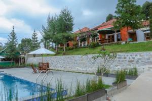 una villa con piscina e una casa di De Bloem Lake View Pangalengan a Pengalongan