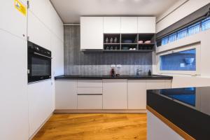 a kitchen with white cabinets and black counter tops at Charming 2 Bedroom Apartment in Cluj-Napoca