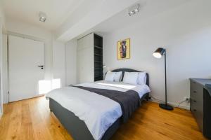 - une chambre avec un grand lit et une lampe dans l'établissement Charming 2 Bedroom Apartment, à Cluj-Napoca