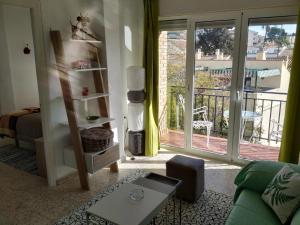 マラガにあるTejas Apartamentoのリビングルーム(緑のソファ、ガラスの引き戸付)