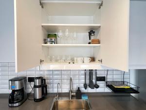 a kitchen with white cabinets and a sink at OlivAparts in Mugla