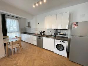 a kitchen with white cabinets and a table and a washer at OlivAparts in Mugla +106 photos