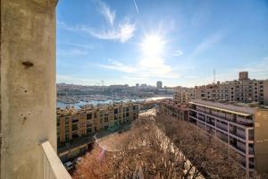 a view of a city with buildings and the sun at Appartement tout équipe Vieux Port 4 couchages in Marseille
