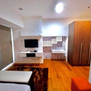 a large living room with a tv and a couch at Modern-Eclectic 1BR- Unit @Milano in Manila