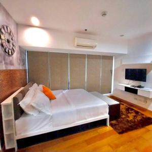 1 dormitorio con 1 cama blanca grande y TV en Modern-Eclectic 1BR- Unit @Milano en Manila