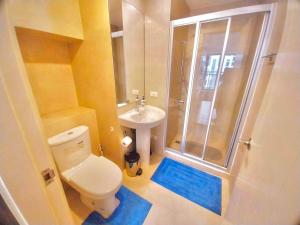 y baño con ducha, aseo y lavamanos. en Modern-Eclectic 1BR- Unit @Milano, en Manila