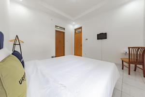 a white bedroom with a bed and a tv at Urbanview Hotel My Honai Setrasari by RedDoorz in Bandung
