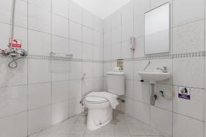 a bathroom with a toilet and a sink at Urbanview Hotel My Honai Setrasari by RedDoorz in Bandung