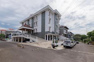 un gran edificio blanco al lado de una calle en RedDoorz Plus near Universitas Maranatha Bandung 2 en Bandung