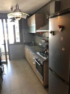 a kitchen with a stainless steel refrigerator and a stove at Luxury Apprt 2 ch ,prestigia des nations in Sidi Bouqnadel