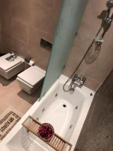 uma casa de banho com uma banheira, um WC e um lavatório. em Luxury Apprt 2 ch ,prestigia des nations em Sidi Bouqnadel