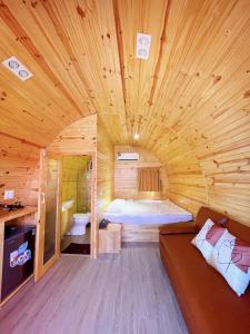 um quarto de madeira com uma cama e um sofá. em Ruby Homestay Cần Giờ 