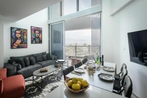 sala de estar con mesa y sofá en Luxury 3BR Duplex with Sea View in Tel-Aviv Center by Sea N' Rent en Tel Aviv