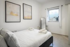 1 dormitorio con 1 cama blanca y 2 toallas en Luxury 3BR Duplex with Sea View in Tel-Aviv Center by Sea N' Rent en Tel Aviv