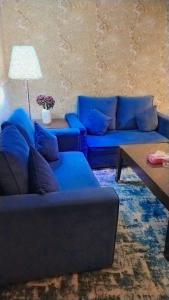 a living room with a blue couch and a table at Blue Sands Al Bilsan Furnished Units in Dammam