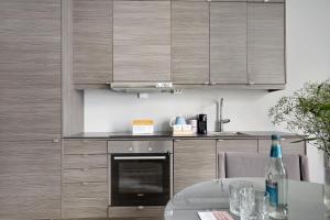 a kitchen with wooden cabinets and a table with a bottle of wine at numa l Topp Apartments in Oslo