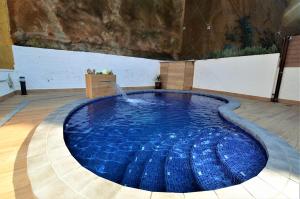 une grande piscine avec une fontaine dans une pièce dans l'établissement Villa Isabel Lloret de mar, à Lloret de Mar