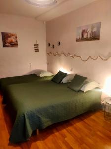1 dormitorio con 1 cama verde en una habitación en Cité de caractère médiéval, en Fresnay-sur-Sarthe