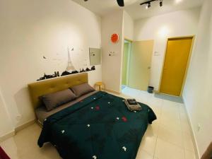 a bedroom with a bed with a green comforter at Cozy 3BR Apartment with Free Netflix in Bayan Lepas