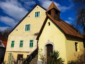 un edificio antiguo con una iglesia con ventanas verdes en HIŠA VELIKANKA_Giantess, en Kostel
