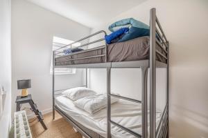 sypialnia z dwoma łóżkami piętrowymi w pokoju w obiekcie Duplex du Littoral - Vue mer w mieście Villers-sur-Mer