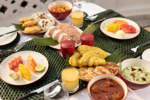 stół z talerzami jedzenia i soku pomarańczowego w obiekcie Jetwing Mahesa Bhawan w mieście Dżafna