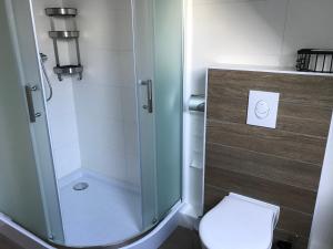 een badkamer met een glazen douche en een toilet bij Zaligheid in Lage Zwaluwe