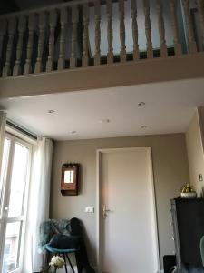 een woonkamer met een trap en een deur bij Zaligheid in Lage Zwaluwe