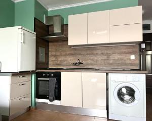 a kitchen with white cabinets and a washing machine at Flower house 2 in Sofia