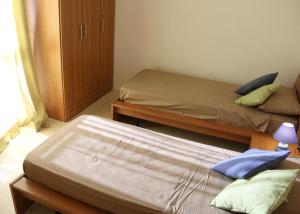 1 dormitorio con 2 camas individuales y armario en St.Joseph Apartment, en Marsaskala