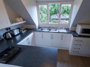 a kitchen with white cabinets and a sink and a window at Taunton in Port Elizabeth