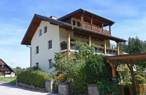 a large white building with a wooden roof at Appartement Mittagskogel in Velden am Wörthersee