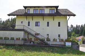 a large white building with stairs and plants at Appartement Mittagskogel in Velden am Wörthersee