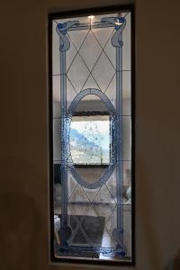 a mirror with a blue glass frame on a wall at Belvedere Beatrice - Rebomaholidays in Olzano