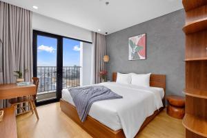 1 dormitorio con 1 cama grande y balcón en Lagom Boutique Hotel Da Nang en Da Nang