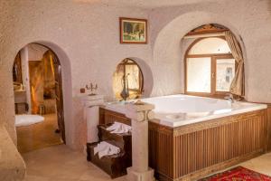 a large bathroom with a tub and a sink at Cappadocia Gamirasu Cave Hotel in Ayvalı