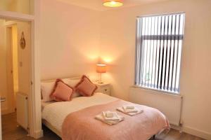 a bedroom with a bed with two towels on it at Contemporary & Stylish House . FREE Parking in Beeston Hill