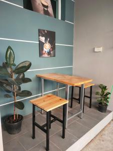 a table and bench in a room with a plant at บ้านไอรัก@the neo 