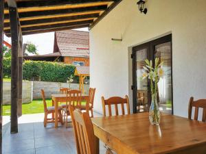 a dining room with a table and chairs and a vase of flowers at Pensiunea Ocna Maramuresului in Ocna Şugatag