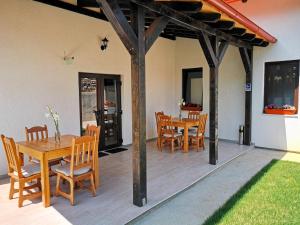 un patio con tavolo e sedie in legno e una sala da pranzo di Pensiunea Ocna Maramuresului a Ocna Şugatag Altre 22 foto