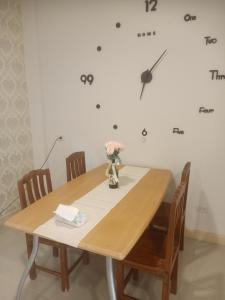 una mesa de madera con sillas y un reloj en la pared en บ้านไอรักbyเดอะนีโอ 