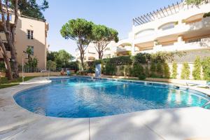 a swimming pool in front of a building at Marbella playa Residencial con piscina in Marbella