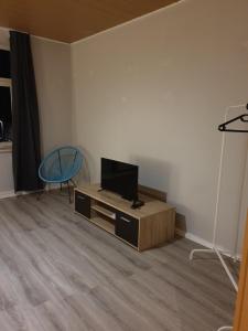 a living room with a tv and a table at FeWo Nina 3 - Monteurwohnung in Weißenfels +5 photos