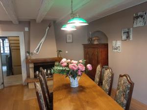 a dining room table with a vase of flowers on it at Dock 23 in Colmar