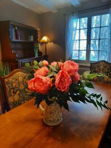 a vase filled with orange roses on a wooden table at Dock 23 in Colmar +40 photos