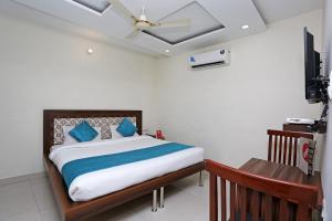 a bedroom with a bed with blue pillows and a ceiling at Hotel Sea in Patiāla